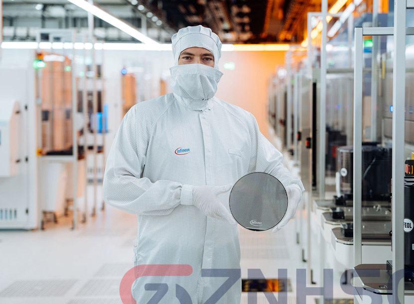 A technical engineer holding a 200mm silicon carbide wafer in the cleanroom of Infineon’s fab in Villach, Austria.